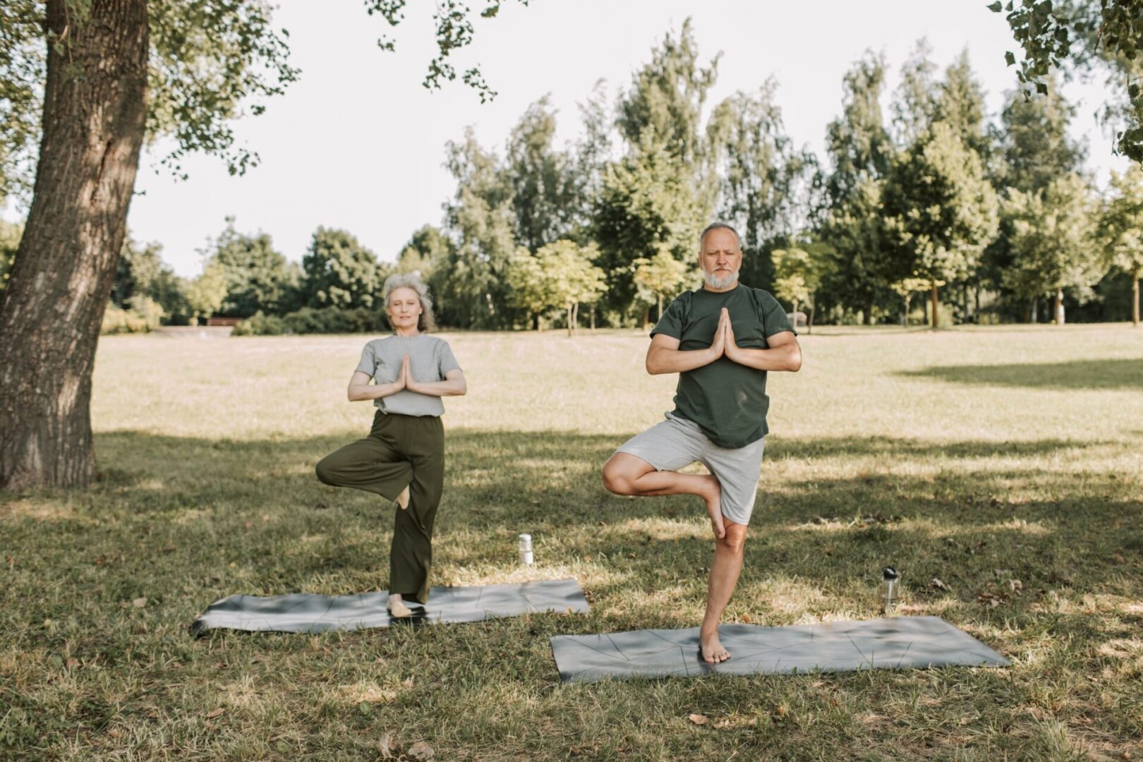 Couple practising yoga in a park